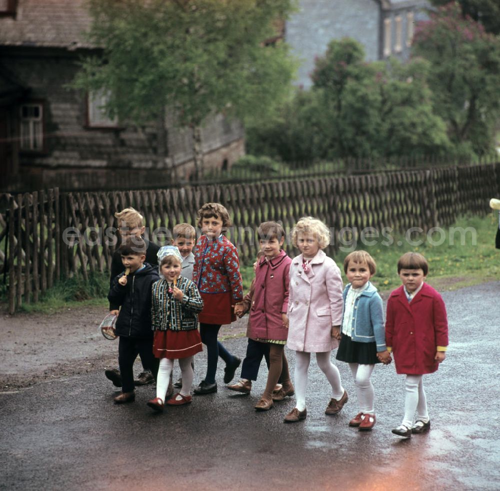 GDR picture archive: Masserberg - Kinder gehen in Masserberg im Thüringer Wald spazieren, zum Pfingstfest tragen sie festliche Kleidung. Der Thüringer Wald mit seinen Wander- und Erholungsmöglichkeiten war ein beliebtes Ausflugs- und Urlaubsziel in der DDR.