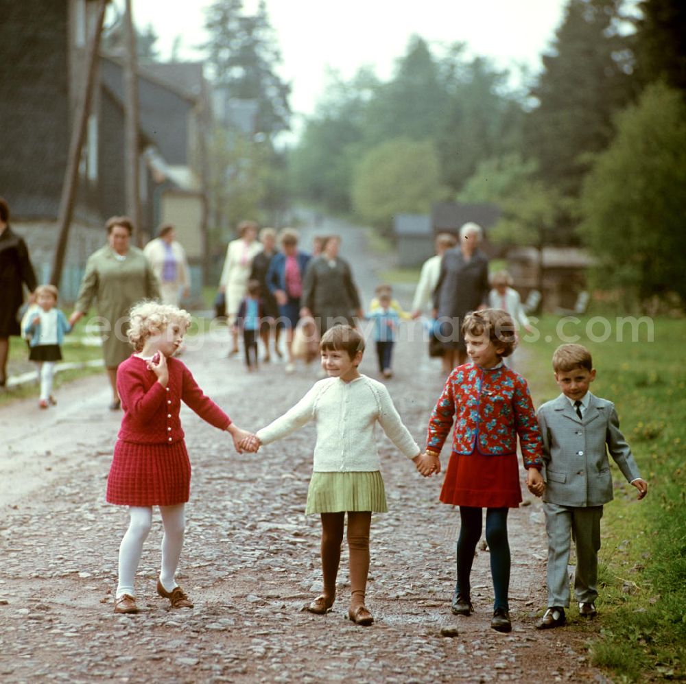 GDR picture archive: Masserberg - Kinder und Frauen gehen in Masserberg im Thüringer Wald spazieren, zum Pfingstfest tragen sie festliche Kleidung. Der Thüringer Wald mit seinen Wander- und Erholungsmöglichkeiten war ein beliebtes Ausflugs- und Urlaubsziel in der DDR.