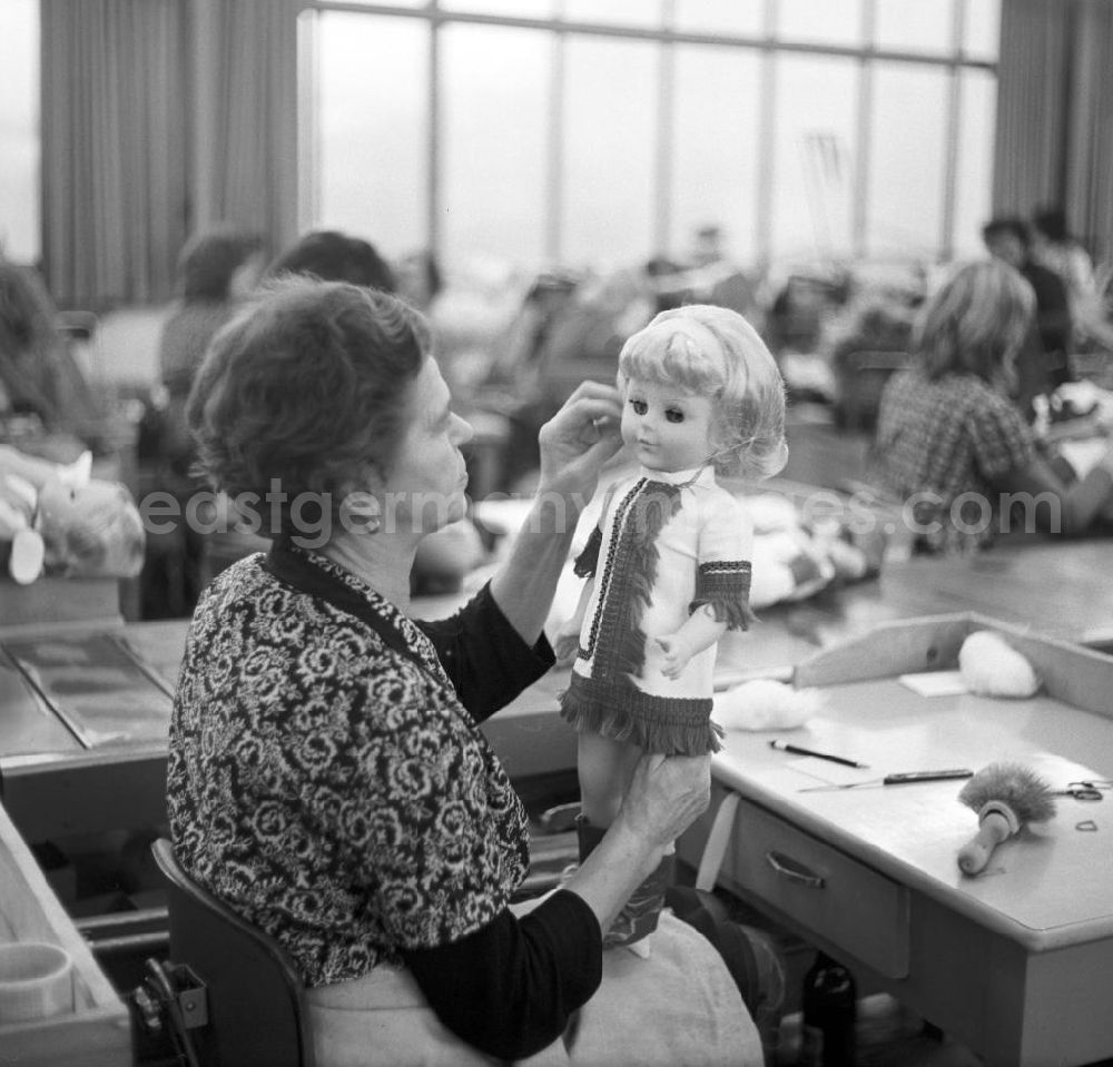 GDR photo archive: Sonneburg - Eine Mitarbeiterin des VEB Kombinat Spielwaren Sonneberg sonni zieht einer Puppe ein Haarnetz über, bevor sie für den Verkauf verpackt wird. Die Sonneberger Puppen waren nicht nur in der DDR beliebt, sondern trugen den Namen der Stadt in alle Welt.
