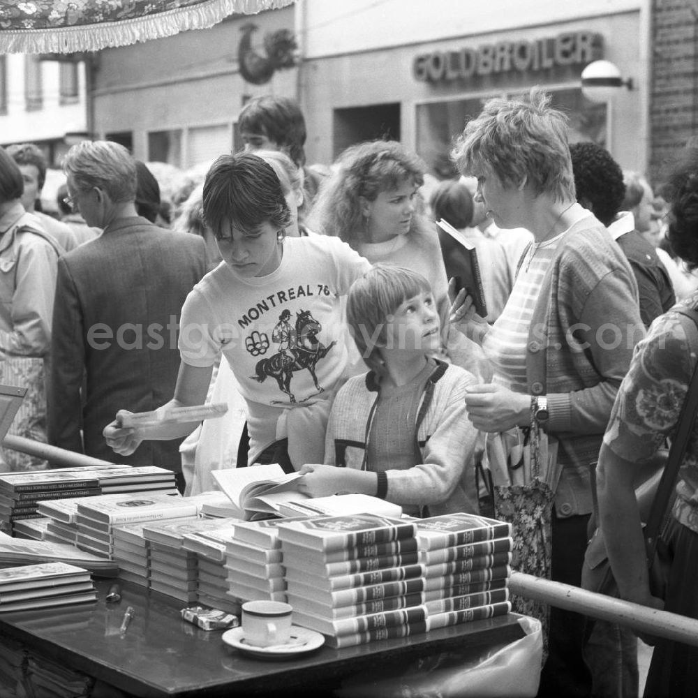 GDR picture archive: Rostock - Besucher an einem Buchstand auf dem Schriftstellerbasar in Rostock.