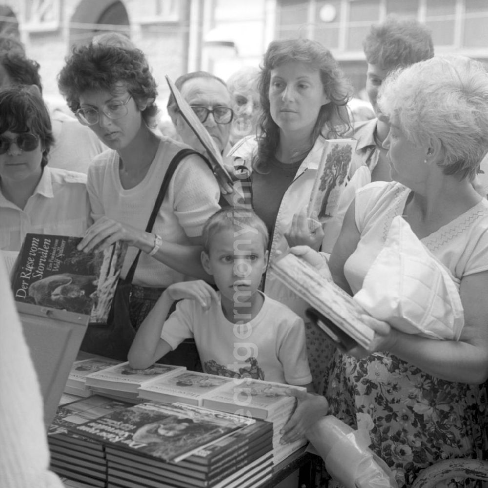 GDR photo archive: Rostock - Dichtes Gedränge herrscht an einem Buchstand auf dem Schriftstellerbasar in Rostock.