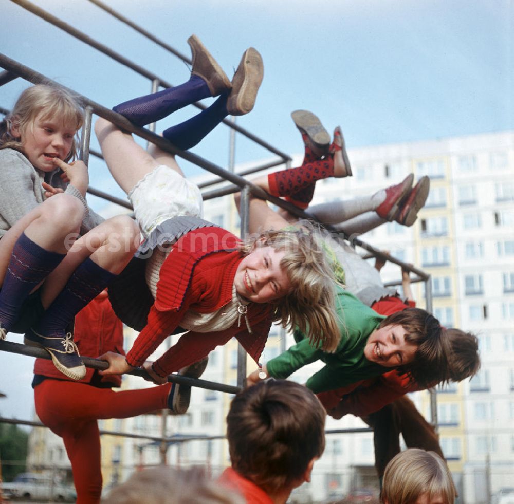 Berlin: Mädchen machen Schweinebammel an der Stange eines Klettergerüstes in Berlin.