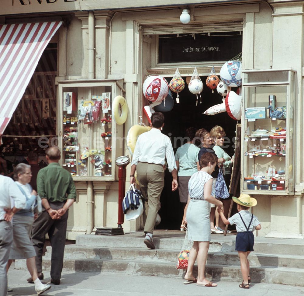 GDR image archive: Ahlbeck - Urlauber betrachten die Schaufenster eines Geschäftes für Kunstgewerbe, Reiseandenken und Badebedarfsartikel in Ahlbeck auf der Insel Usedom.