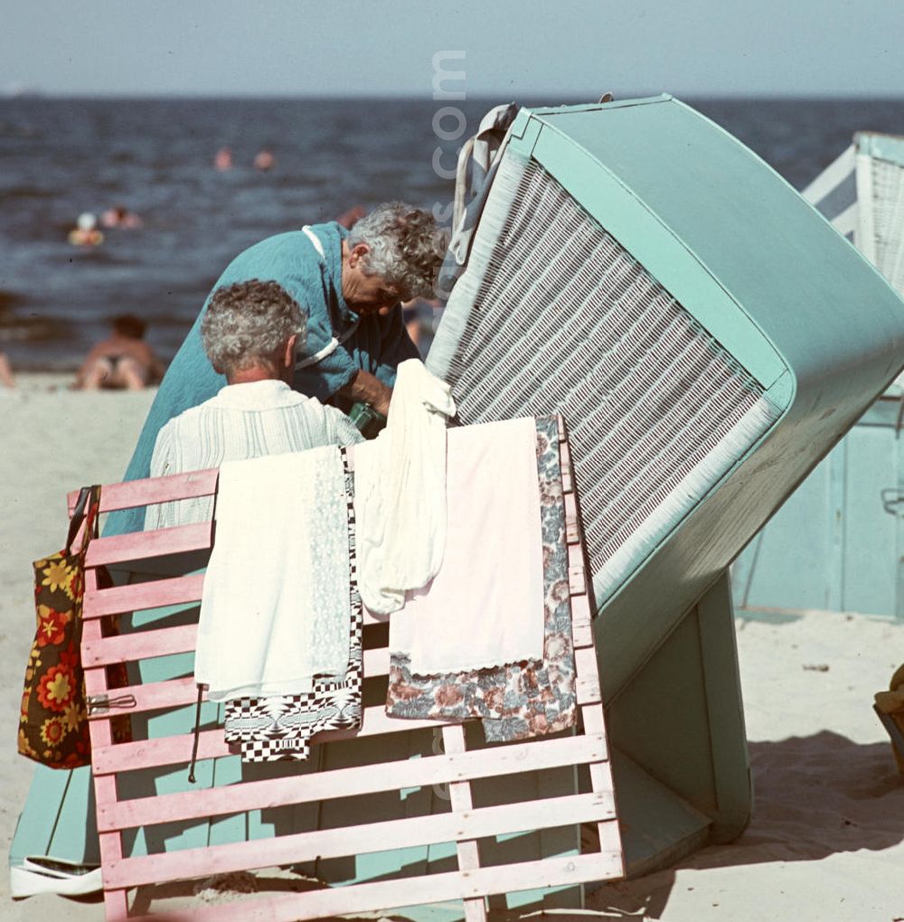 Ahlbeck: Im Schutz des Strandkorbes ziehen sich zwei Frauen am Ostseestrand bei Ahlbeck auf der Insel Usedom um.