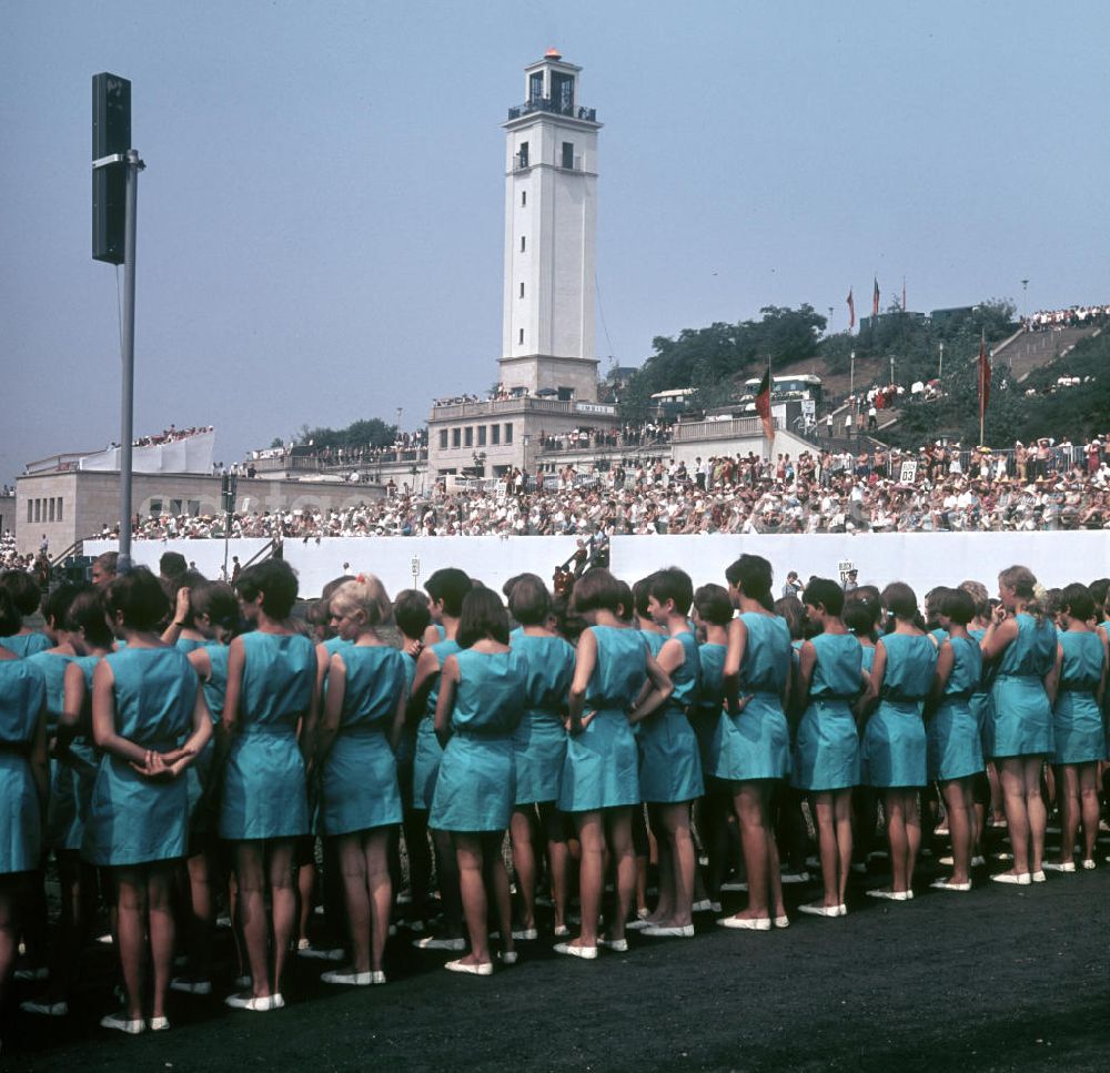 GDR picture archive: Leipzig - Turnerinnen des V. Turn- und Sportfestes der DDR vom 24. bis 27.7.1969 in Leipzig auf der Festwiese vor dem Glockenturm und dem Leipziger Zentralstadion.