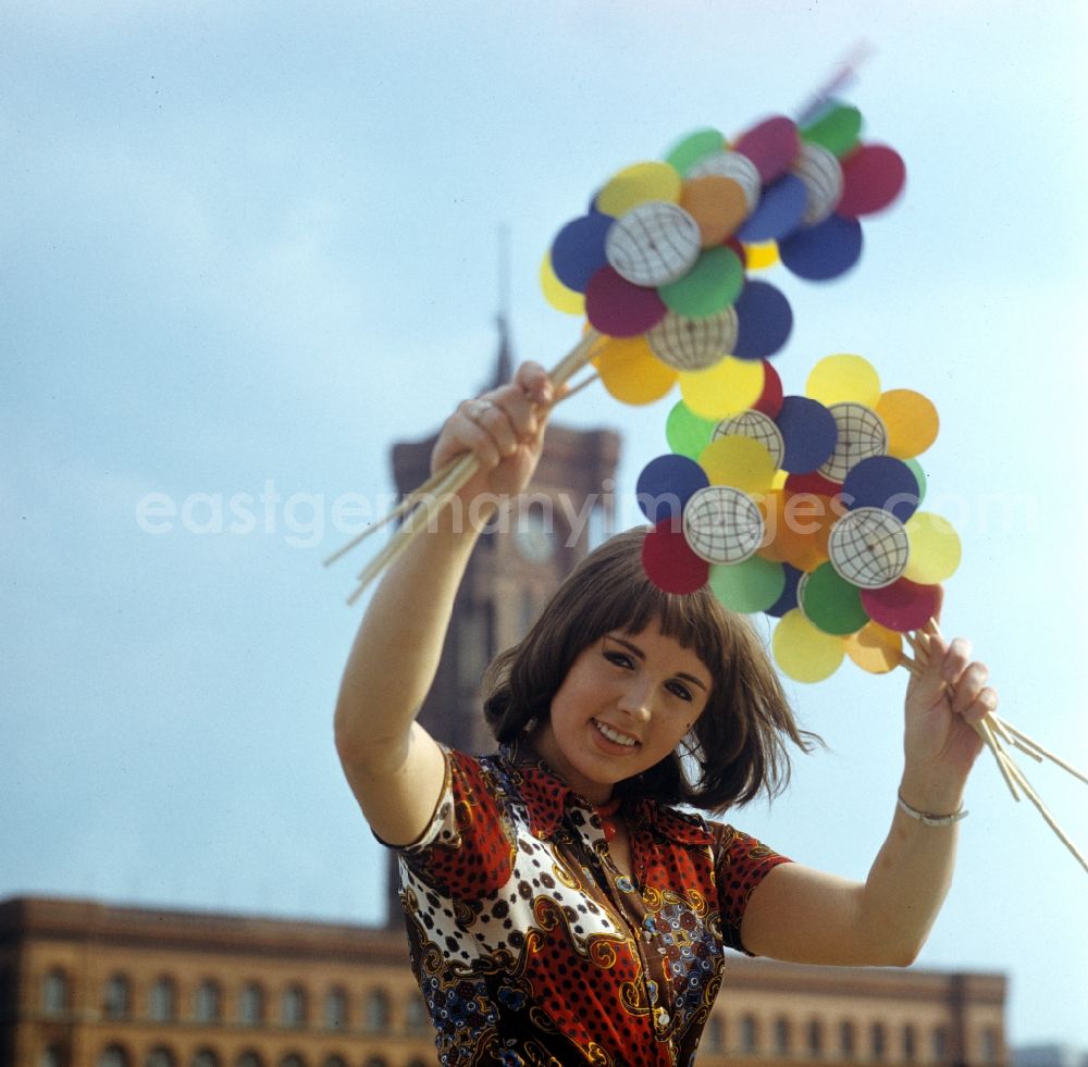 GDR photo archive: Berlin - Eine junge Frau hält Windmühlen mit dem Logo der X. Weltfestspiele 1973 in Berlin in den Händen. A young woman holding windmills with the logo of X. World Festival 1973 in Berlin in the hands.