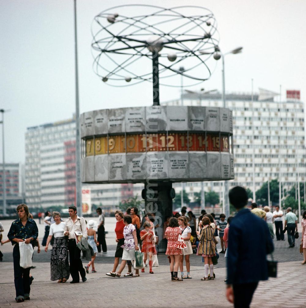GDR photo archive: Berlin - Touristen und Einheimische flanieren über den Berliner Alexanderplatz und besichtigen die Weltzeituhr.
