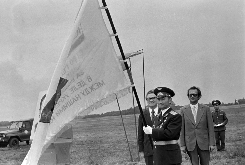 GDR photo archive: Ribnitz-Damgarten - Kurt Thieme (General Secretary of the Central Board of the Society for German-Soviet Friendship DSF) with an NVA Air Force delegation at the awarding of a ribbon of honor to the troop flag of the officers of the GSSD Group of Soviet Armed Forces in Germany at the airfield in Ribnitz-Damgarten, Mecklenburg- Western Pomerania in the territory of the former GDR, German Democratic Republic