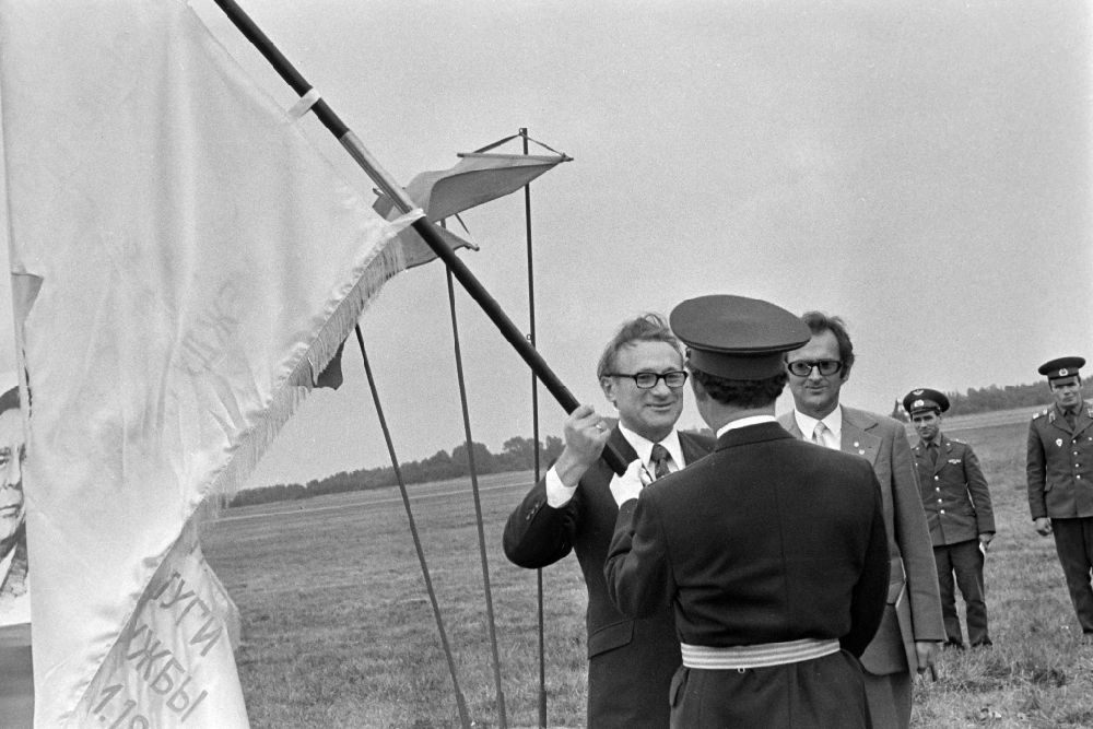 GDR picture archive: Ribnitz-Damgarten - Kurt Thieme (General Secretary of the Central Board of the Society for German-Soviet Friendship DSF) with an NVA Air Force delegation at the awarding of a ribbon of honor to the troop flag of the officers of the GSSD Group of Soviet Armed Forces in Germany at the airfield in Ribnitz-Damgarten, Mecklenburg- Western Pomerania in the territory of the former GDR, German Democratic Republic