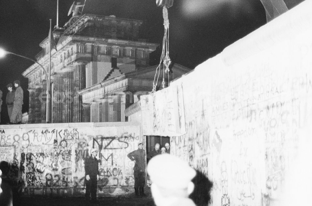 GDR photo archive: Berlin - Demontage von Betonsegmenten der Berliner Mauer zur Öffnung eines Grenzüberganges am Brandenburger Tor in Berlin- Mitte. Durch Baupioniere und Soldaten der Grenztruppen der DDR wurden L- Profile aus der ehmaligen Befestigungsanlage der DDR Staatsgrenze zu Westberlin entfernt.// Dismantling of concrete segments of the Berlin Wall to the opening of a border crossing at the Brandenburg Gate in Berlin-Mitte. By Baupioniere and soldiers of the Border Troops of the GDR L-profiles were removed from the ramparts of the GDR border to West Berlin.