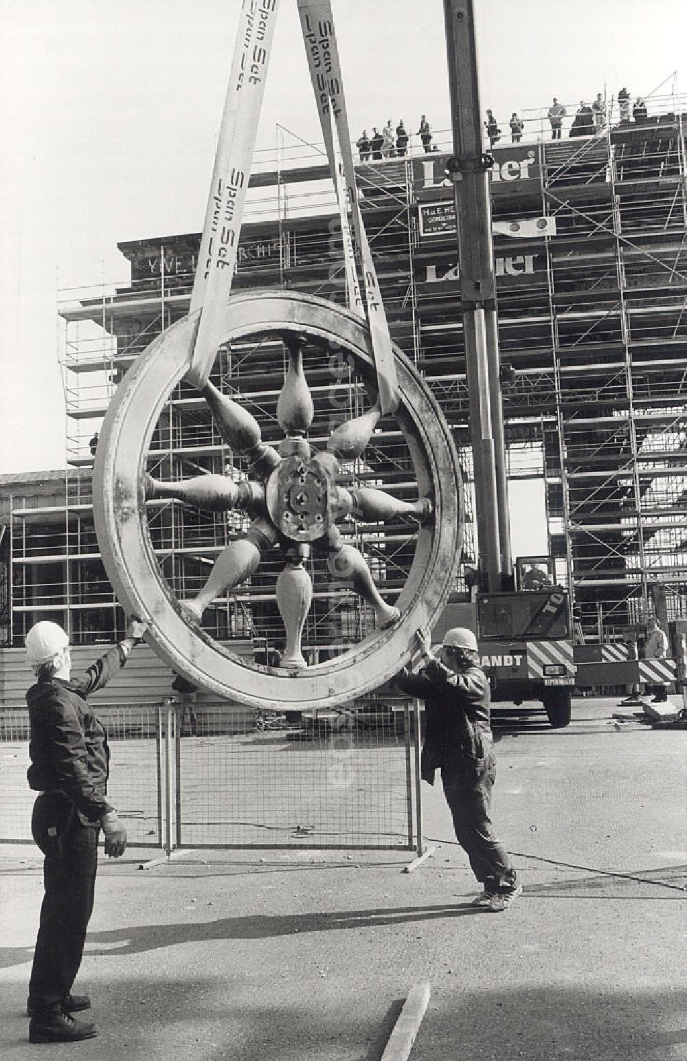 GDR image archive: Berlin - Demontage der Quadriga vom Brandenburger Tor für die Sanierung. Arbeiter vor, am Kran, hängendem Rad der Quadriga am Brandenburger Tor.