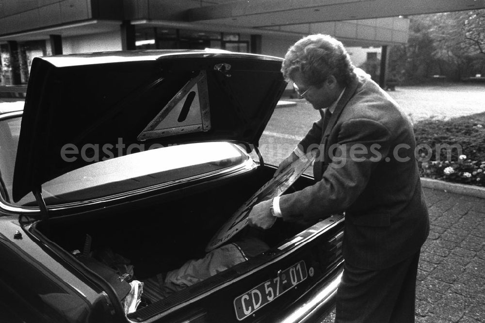 GDR photo archive: Berlin - Demontage vom Vertretungsschild der BRD (Ständige Vertretung) in der Hannoverschen Strasse. Mann legt das Schild in den Kofferraum eines Mercedes-Benz.