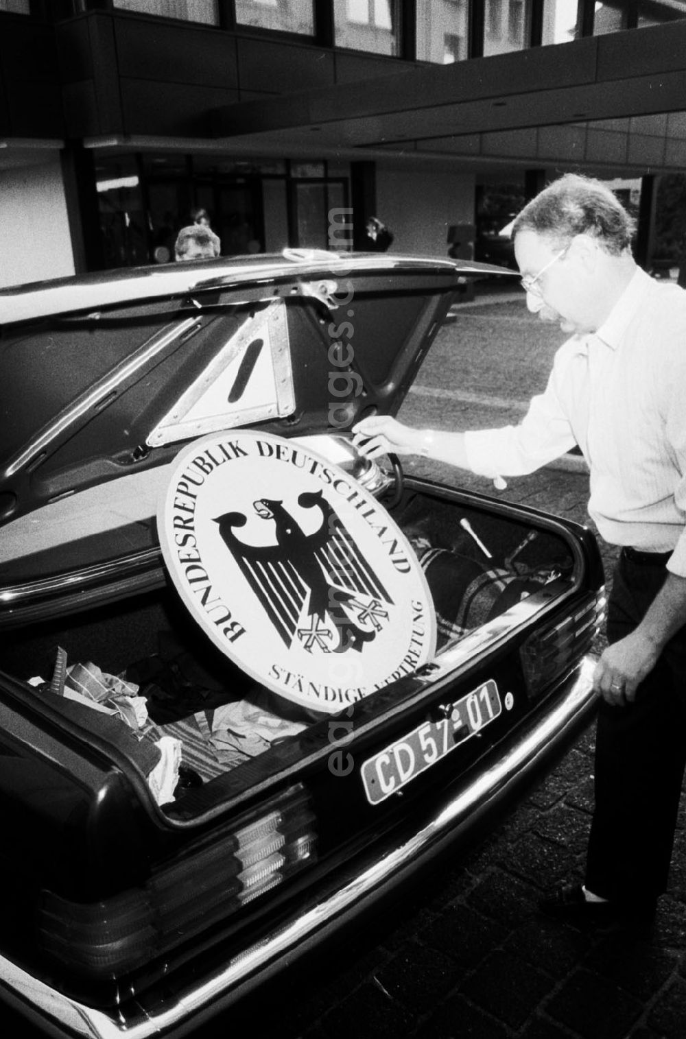 GDR picture archive: Berlin - Demontage vom Vertretungsschild der BRD (Ständige Vertretung) in der Hannoverschen Strasse. Mann legt das Schild in den Kofferraum eines Mercedes-Benz.