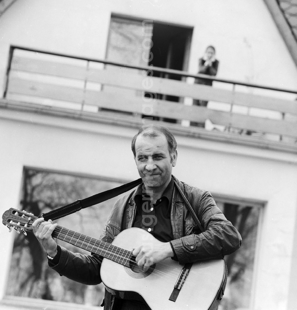 GDR image archive: Berlin - The actor, musician, painter and writer Armin Mueller-Stahl with his guitar in front of his house in Berlin -. Koepenick, the former capital of the GDR, the German Democratic Republic On the balcony, his wife Gabriele