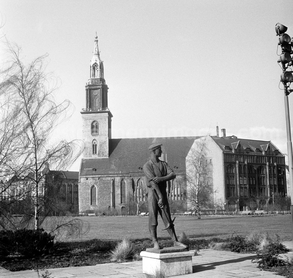 GDR image archive: Berlin - Mitte - The Protestant Mary's Church near the Alexanderplatz in Berlin - Mitte. In the foreground a Bronze statue a worker with pickax