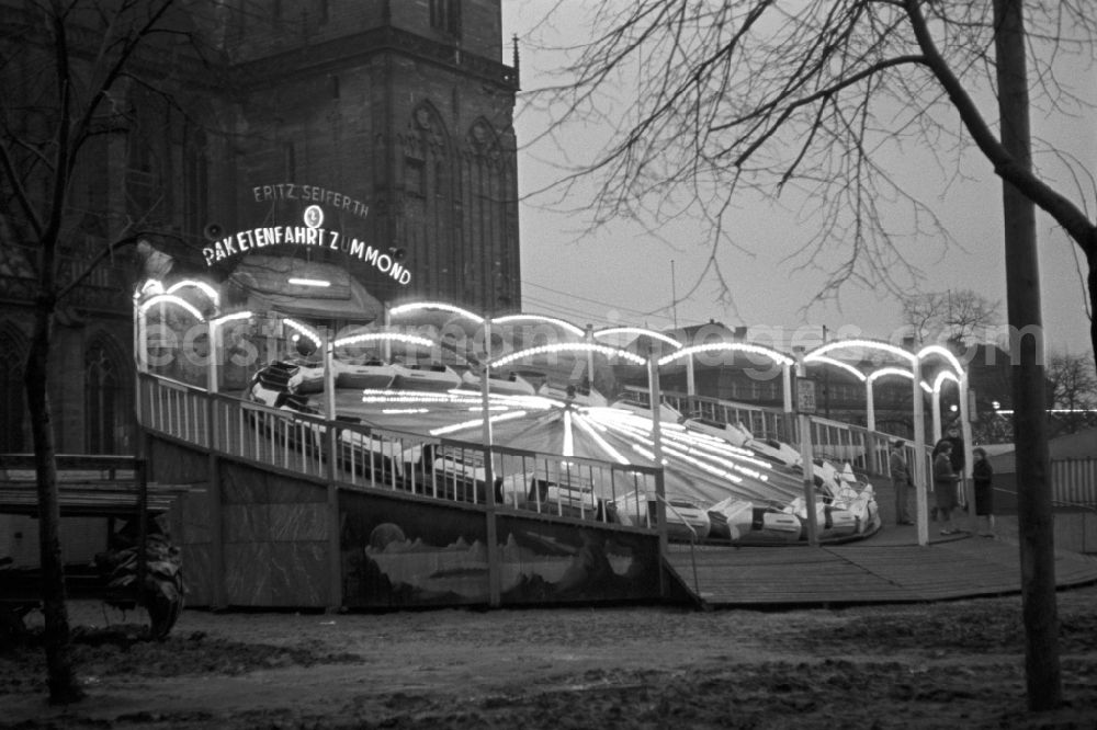 GDR picture archive: Magdeburg - The Magdeburg Spring Fair, a three-week frenzy early spring, takes place annually at the Exhibition Place Max Wille at the Small Town march right on the banks of the Elbe. Here the ride rocket ride to the moon, a Schlickerbahn or sleigh ride called the showman family Seiferth