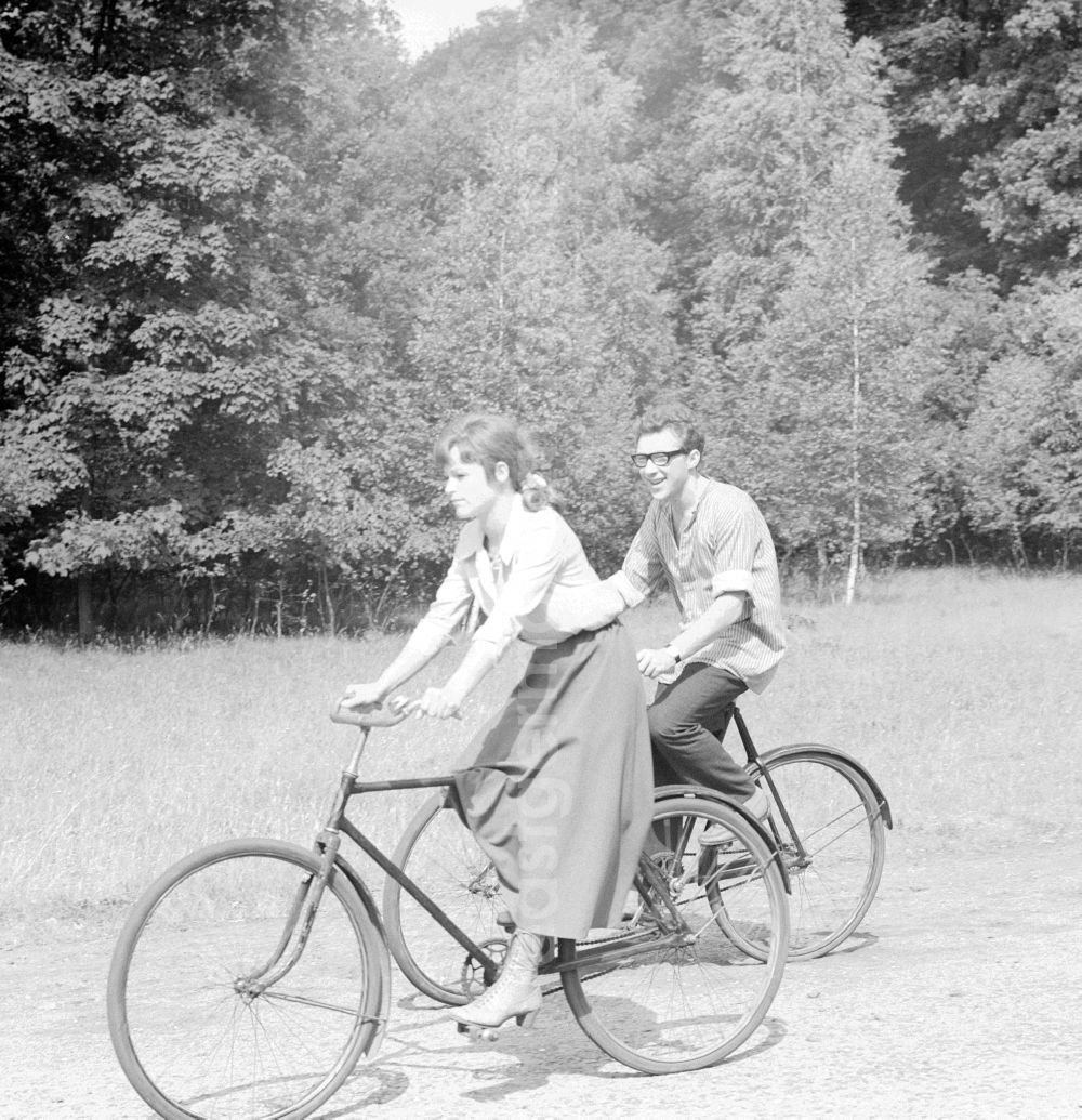 GDR image archive: Potsdam - The actor Angelica Domroese and Jaecki Black cycling in Potsdam in Brandenburg on the territory of the former GDR, German Democratic Republic. Here shooting at the DEFA to the 5- part television series Krupp and Krause in Sanssouci