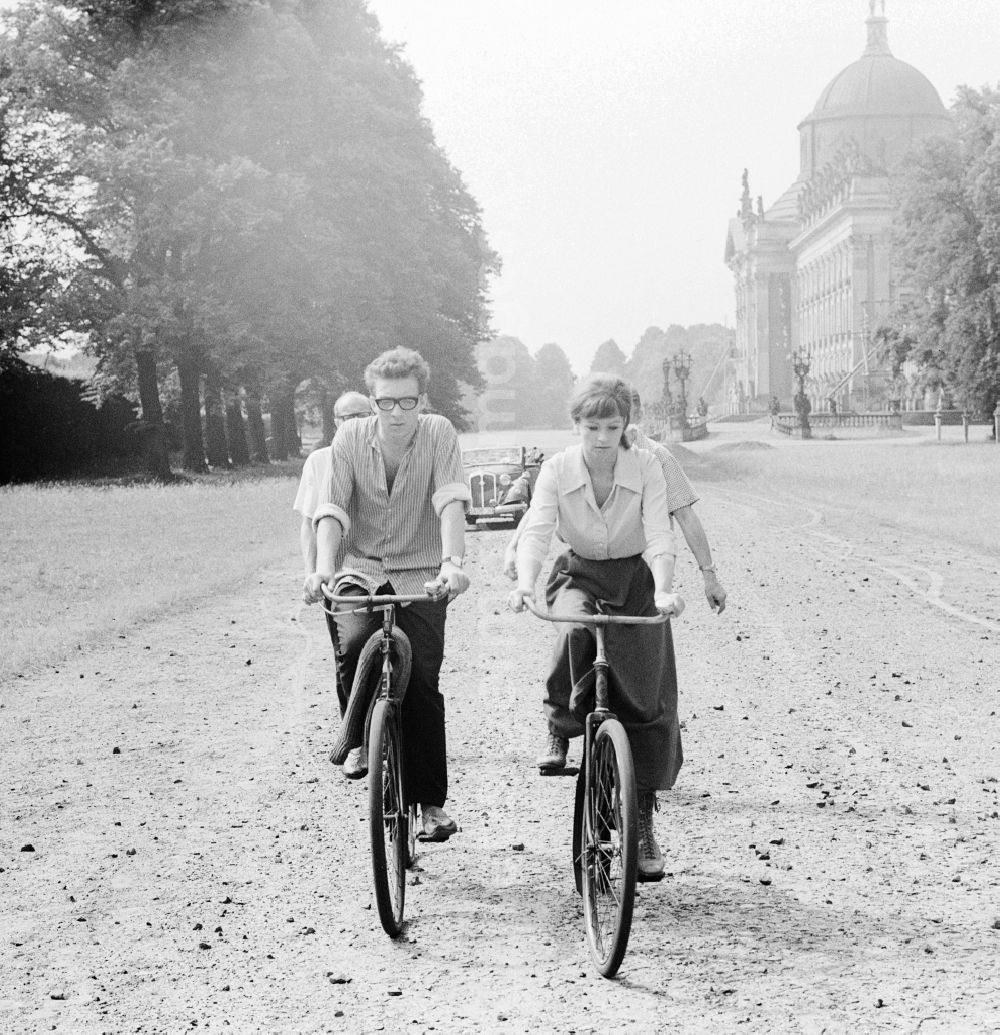 GDR photo archive: Potsdam - The actor Angelica Domroese and Jaecki Black cycling in Potsdam in Brandenburg on the territory of the former GDR, German Democratic Republic. Here shooting at the DEFA to the 5- part television series Krupp and Krause in Sanssouci
