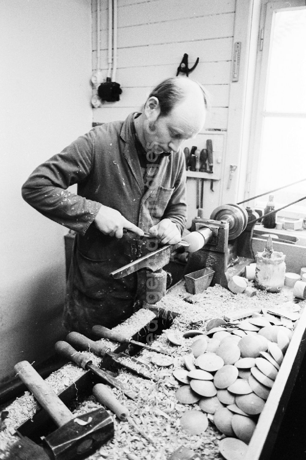 GDR picture archive: Seiffen - Wood turner in the production of nut crackers in the workshops VERO in the health resort Seiffen in the federal state Saxony in the area of the former GDR, German democratic republic