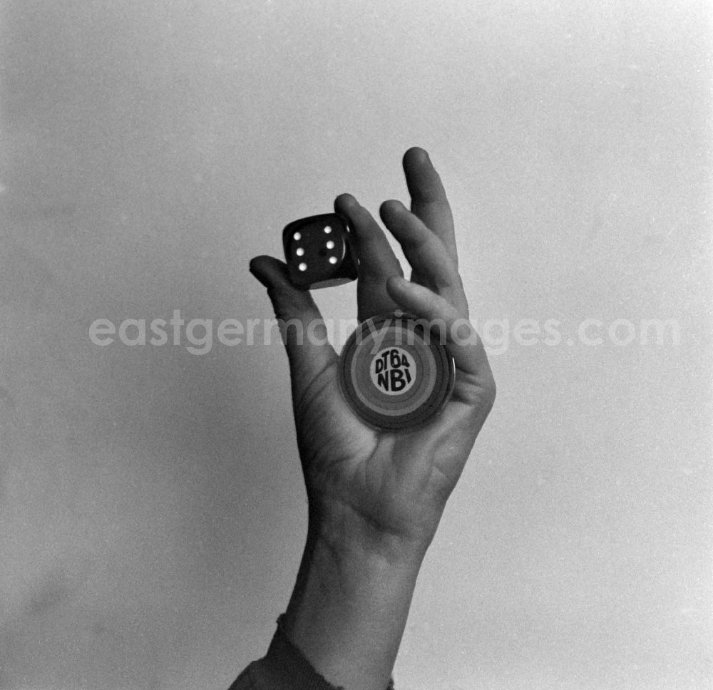 GDR image archive: Berlin - Hand with the DT 64 badge and a cube in Berlin East Berlin on the territory of the former GDR, German Democratic Republic. Under the lettering DT 64 is the term NBI, which stands for the newspaper Neue Berliner Illustrierte