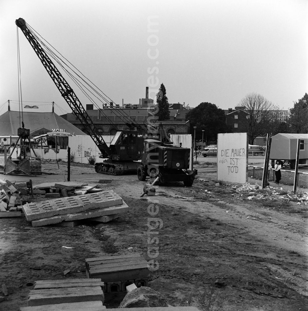 GDR picture archive: Berlin - Dismantling of the Berlin Wall at Michaelkirchplatz between Berlin - Kreuzberg and Berlin - Mitte. The Wall is dead stands on a wall segment. On the left the tent of the Variete mobil