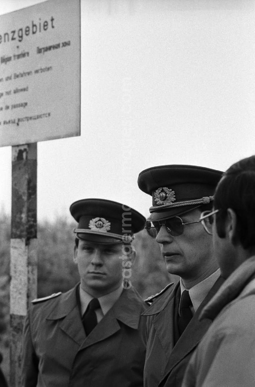 GDR photo archive: Hohen Neuendorf - Mauerfall / Volkspolizisten in Uniform stehen zusammen an der Grenze am ehemaligen Sperrgebiet Stolpe, dahinter Hinweis-Schild Grenzgebiet.