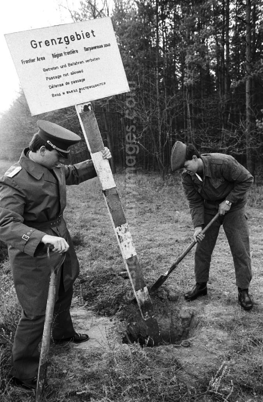 Hohen Neuendorf: Mauerfall / Ein Volkspolizist und ein NVA-Soldat entfernen ein Hinweis-Schild mit der Aufschrift Grenzgebiet im ehemaligen Sperrgebiet Stolpe.