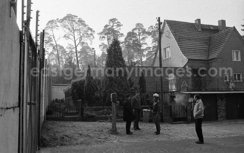 GDR photo archive: Hohen Neuendorf - Männer / Anwohner stehen zusammen vor Mauer / Grenze im ehemaligen Sperrgebiet Stolpe, im Hintergrund steht ein Einfamilienhaus direkt neben der Mauer.