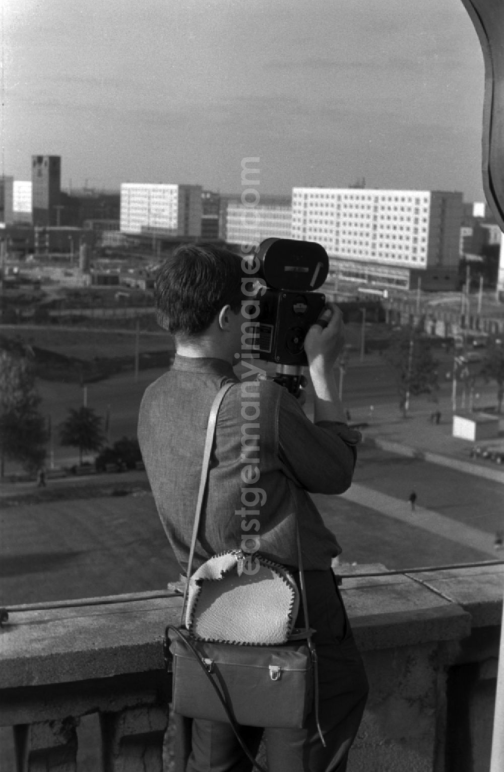 Berlin - Mitte: A young man standing on a balcony and filmed with a 16 mm film camera in Berlin - Mitte