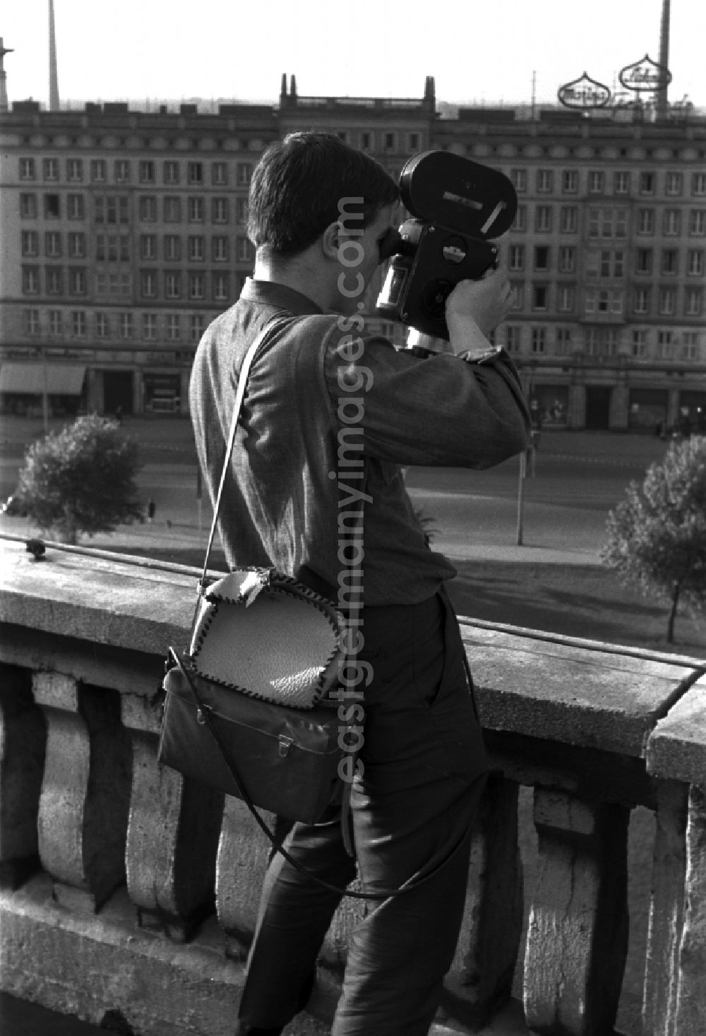 GDR image archive: Berlin - Mitte - A young man standing on a balcony and filmed with a 16 mm film camera in Berlin - Mitte