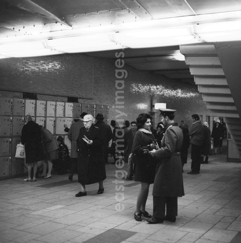 GDR photo archive: Berlin - A young couple in love in Berlin, the former capital of the GDR, German Democratic Republic. A soldier of the National People's Army (NVA) meets with his girlfriend in the basement of a train station in front of the lockers