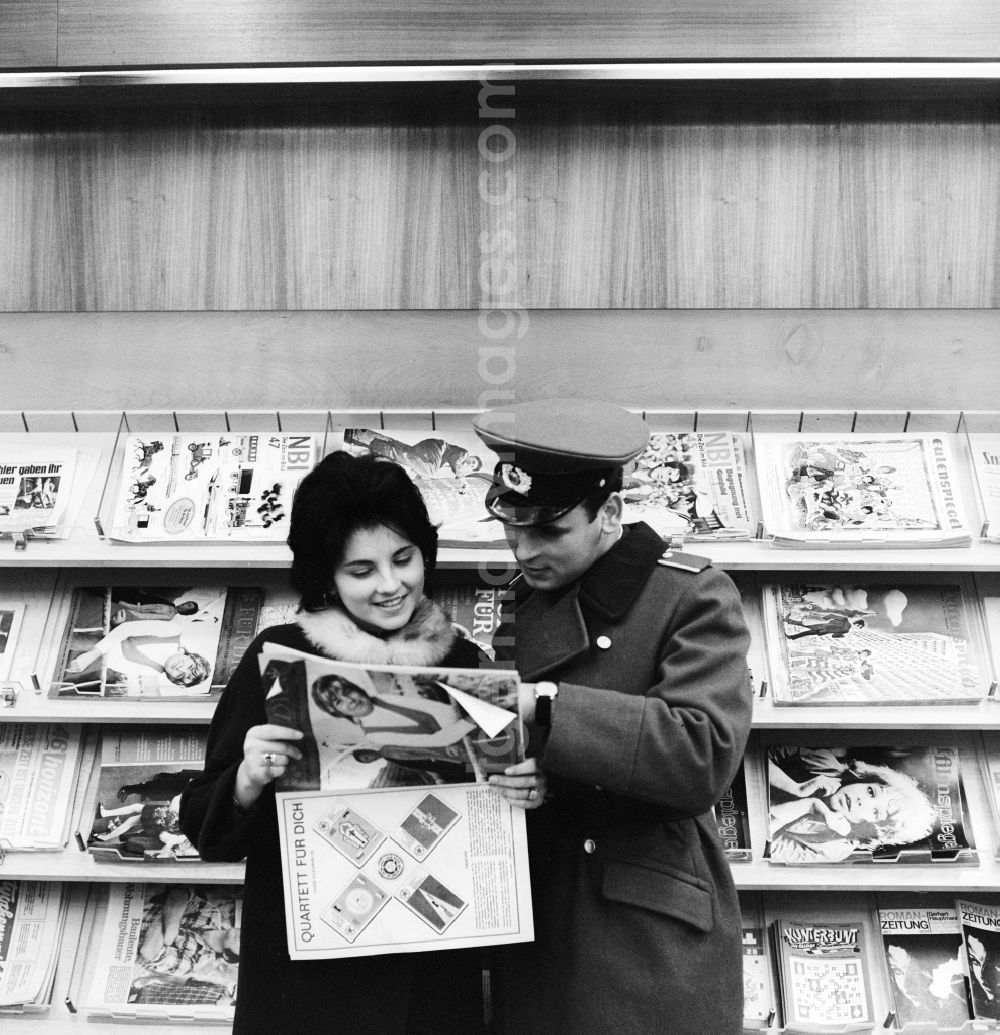 GDR photo archive: Berlin - A soldier of the National People's Army (NVA) stands with his girlfriend in a newsagent in Berlin, the former capital of the GDR, German Democratic Republic