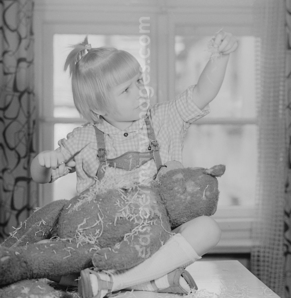 GDR image archive: Berlin - A child cuts up a teddy bear in Berlin, the former capital of the GDR, German Democratic Republic