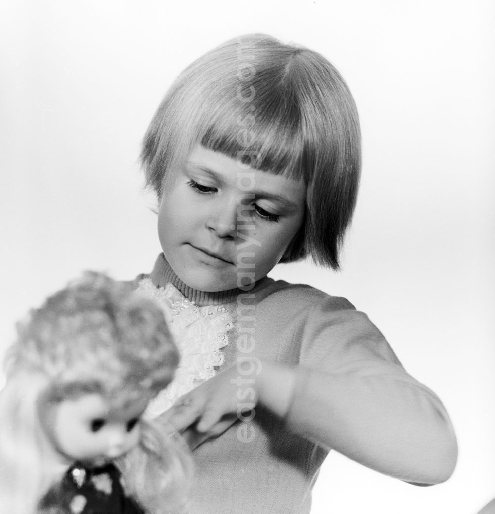 Berlin: A small child playing with a doll in Berlin, the former capital of the GDR, German Democratic Republic