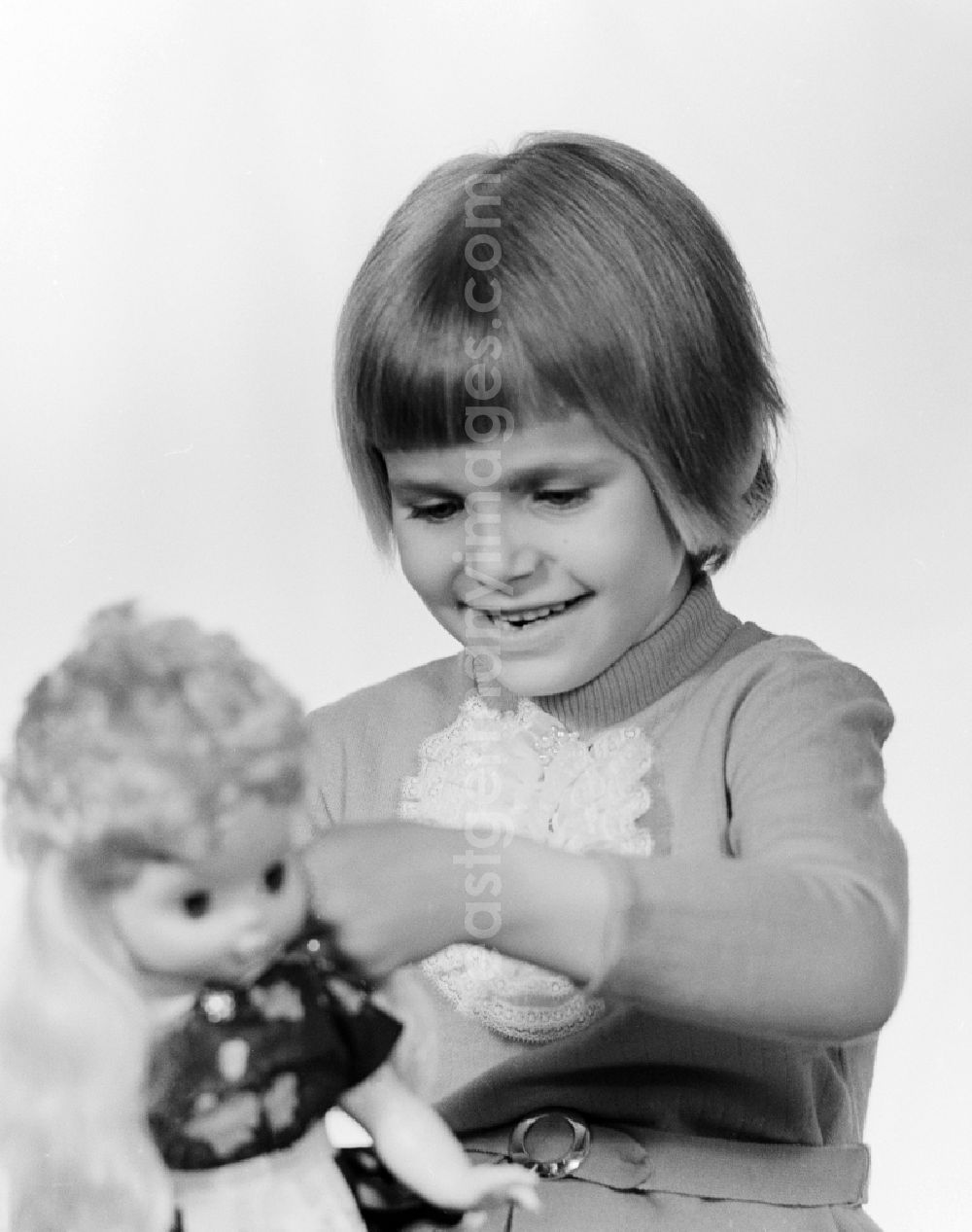 GDR image archive: Berlin - A small child playing with a doll in Berlin, the former capital of the GDR, German Democratic Republic
