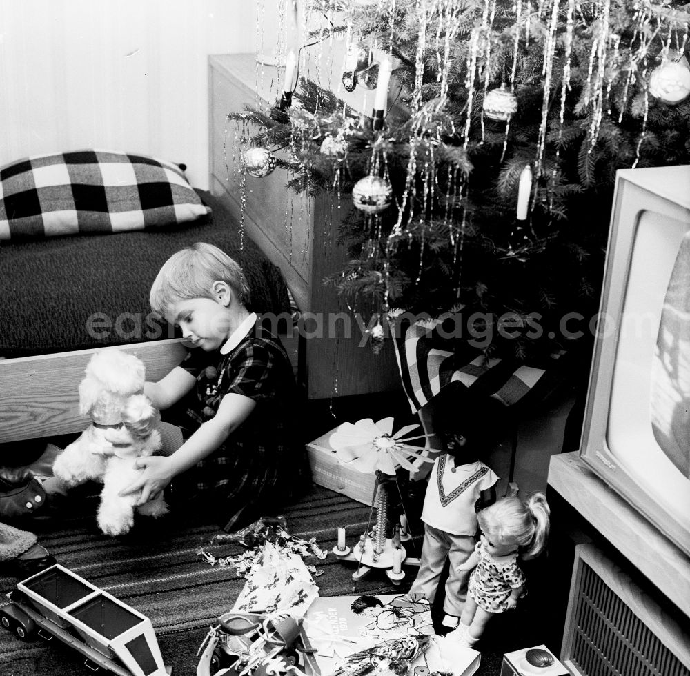 GDR image archive: Berlin - A small child plays with his Christmas presents under the Christmas tree in Berlin, the former capital of the GDR, German democratic republic