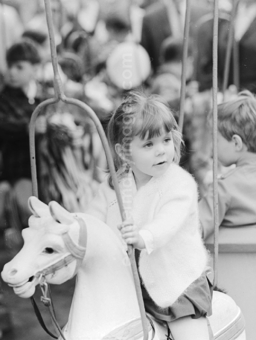 Berlin: A little girl on a carousel horse in Berlin, the former capital of the GDR, the German Democratic Republic