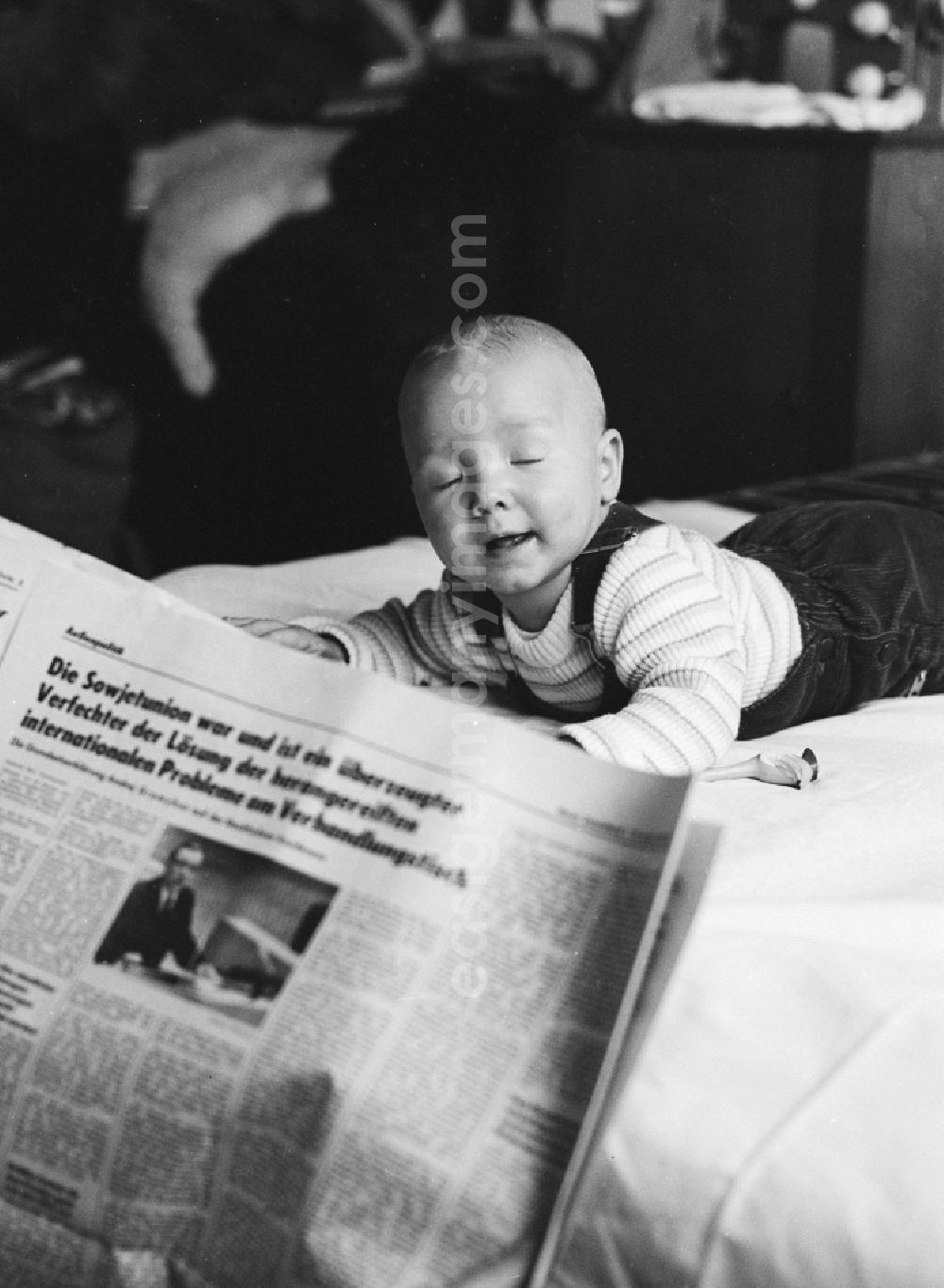 GDR image archive: Berlin - A toddler on a playmat in Berlin, the former capital of the GDR, the German Democratic Republic. In the foreground, a daily newspaper