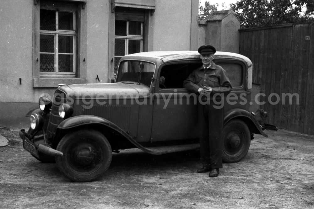 GDR picture archive: Sandersdorf-Brehna - A man by an Opel P4 convertible saloon in outwash plain village-Brehna in the federal state Saxony-Anhalt in Germany