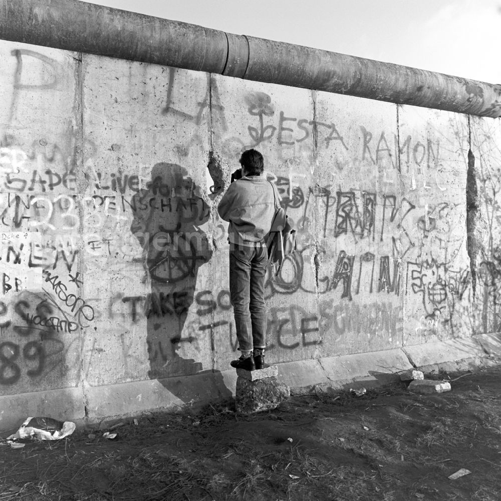 GDR image archive: Berlin - Mitte - A man photographs through a crack in the Berlin Wall in Berlin
