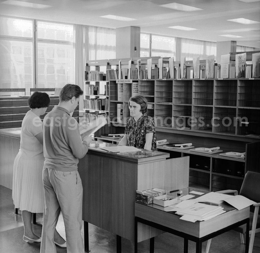 GDR image archive: Berlin - Mitte - A couple is interested in the rental of records from the German State Library in Berlin - Mitte. The German State Library was the central academic library of the German Democratic Republic and acted together with the German Library in Leipzig as the national library