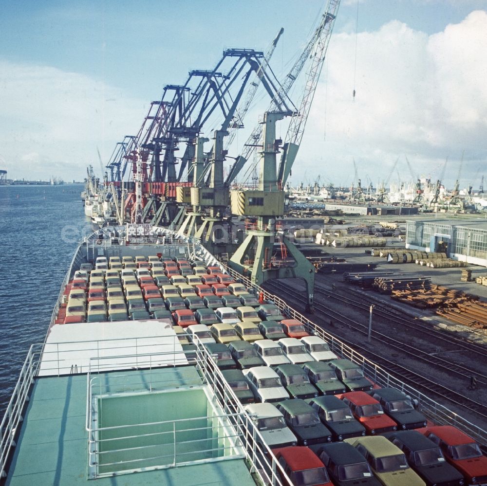 GDR picture archive: Rostock - A ship loaded with passenger cars of the type LADA in the overseas port in Rostock in Mecklenburg-Western Pomerania. In the background loading cranes for loading ships