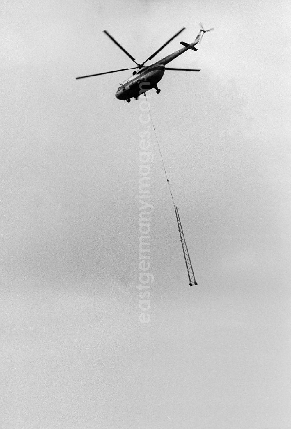 GDR picture archive: Seddiner See - A transport helicopter of the type Mi8 transports driving poles in Seddiner See in the federal state Brandenburg in the area of the former GDR, German democratic republic
