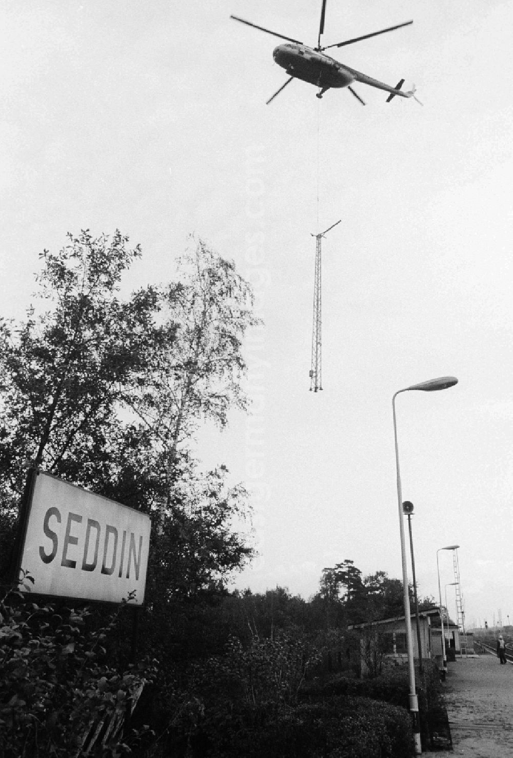 GDR image archive: Seddiner See - A transport helicopter of the type Mi8 transports driving poles to the railway station Seddin of the German national railway in Seddiner See in the federal state Brandenburg in the area of the former GDR, German democratic republic