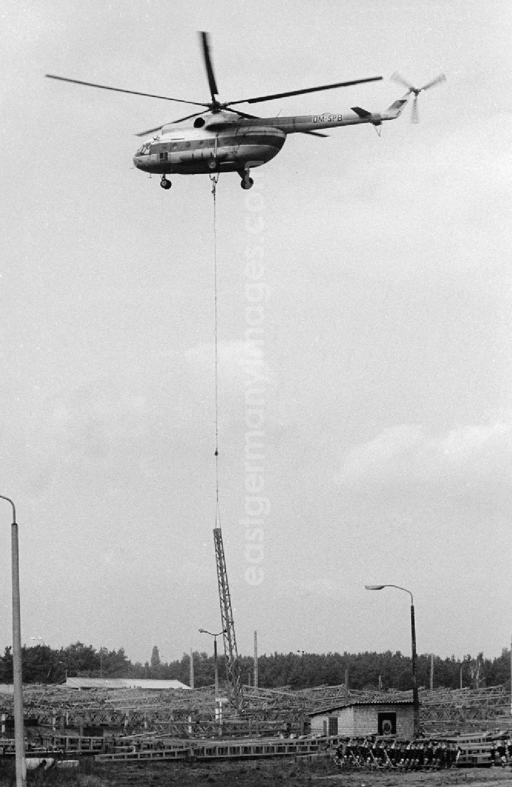 GDR picture archive: Seddiner See - A transport helicopter of the type Mi8 transports driving poles to the railway station Seddin of the German national railway in Seddiner See in the federal state Brandenburg in the area of the former GDR, German democratic republic