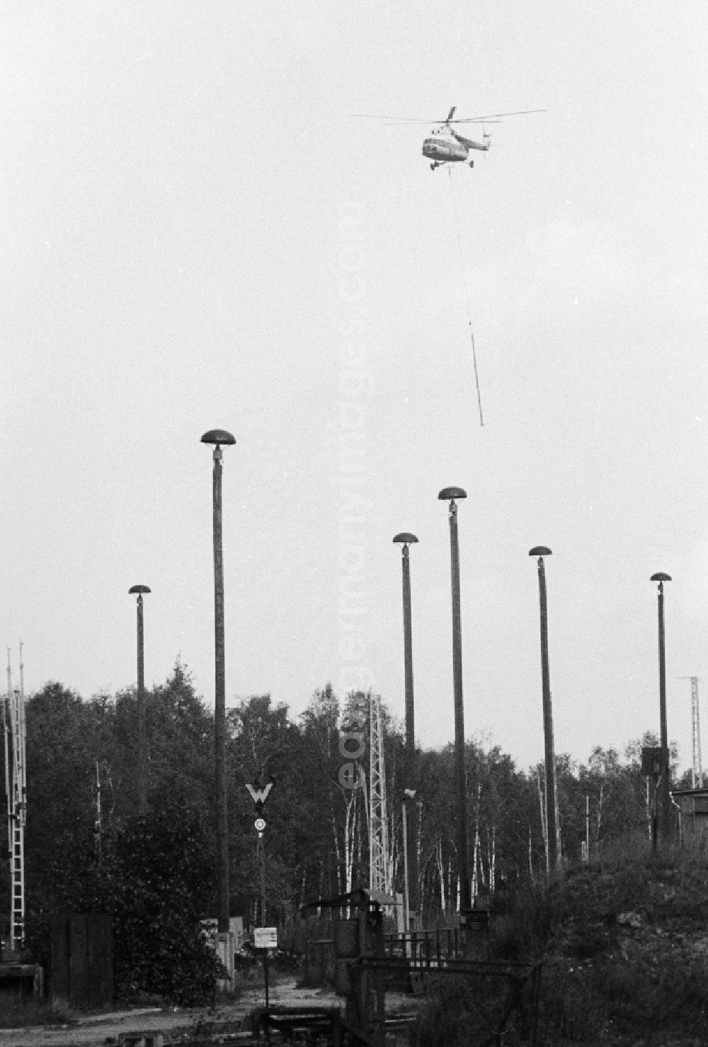 Seddiner See: A transport helicopter of the type Mi8 transports driving poles to the railway station Seddin of the German national railway in Seddiner See in the federal state Brandenburg in the area of the former GDR, German democratic republic