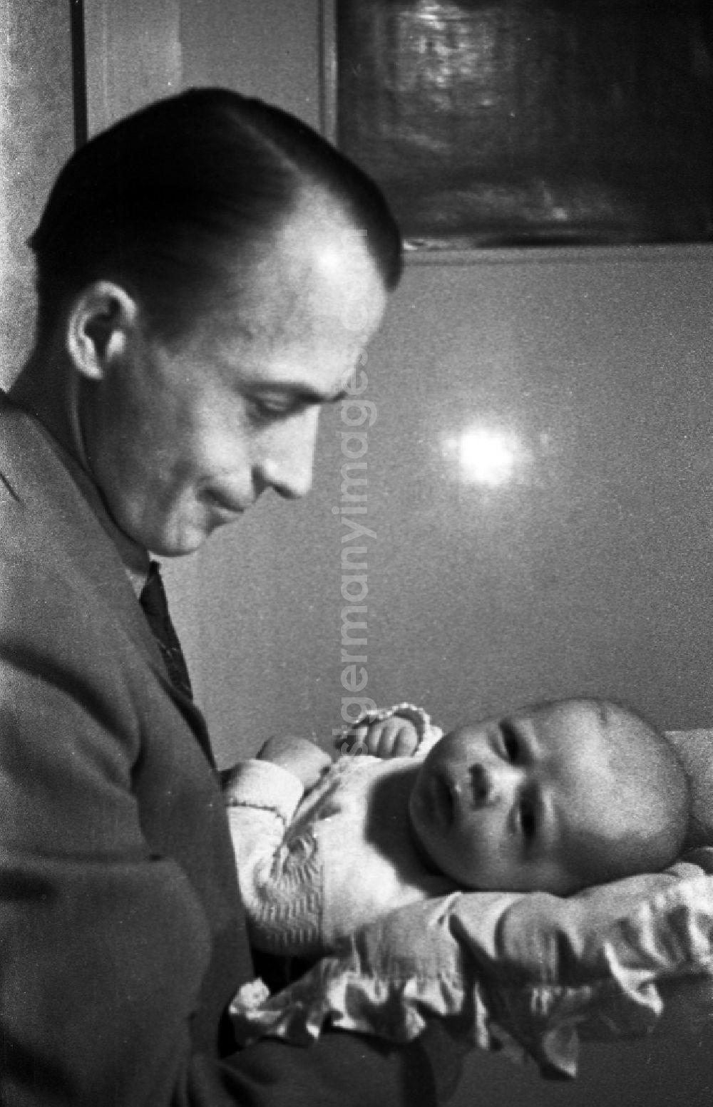 GDR photo archive: Merseburg - A father holds proudly his baby on the arm in Merseburg in the federal state Saxony-Anhalt in the area of the former GDR, German democratic republic