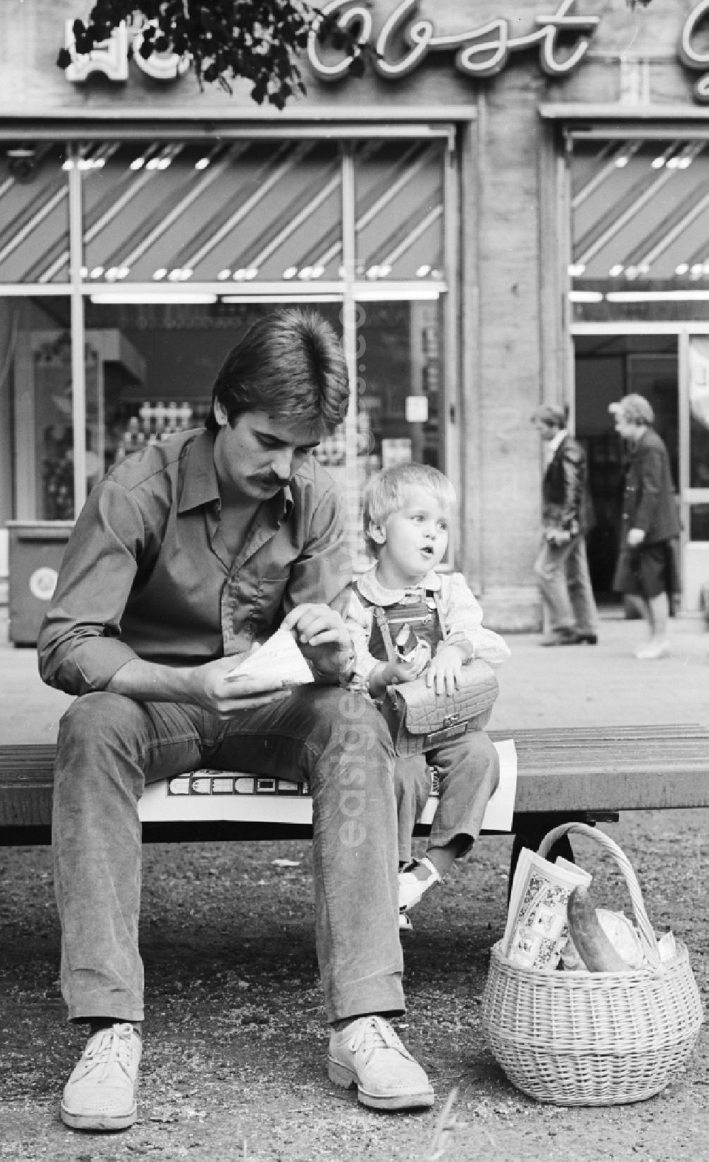 GDR photo archive: Berlin - A father sitting with his child on a bench in the Karl-Marx-Allee in Berlin, the former capital of the GDR, the German Democratic Republic