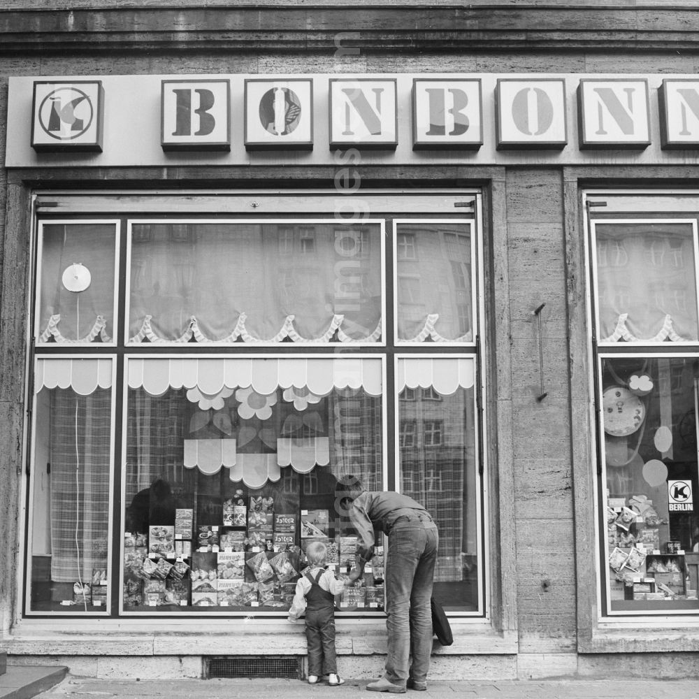 Berlin: A father is KONSUM -lding his child in front of a KONSUM - grocers in the district Friedrichshain in Berlin, the former capital of the GDR, the German Democratic Republic