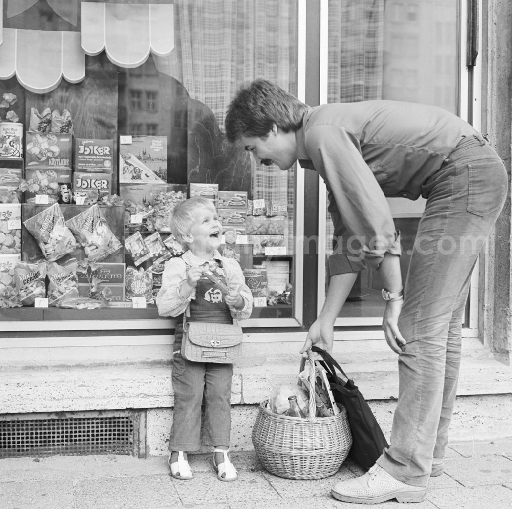 GDR image archive: Berlin - A father is KONSUM -lding his child in front of a KONSUM - grocers in the district Friedrichshain in Berlin, the former capital of the GDR, the German Democratic Republic